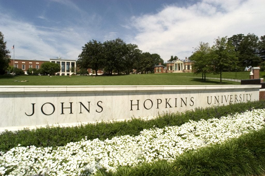 Image of the Johns Hopkins University sign with the library in the background